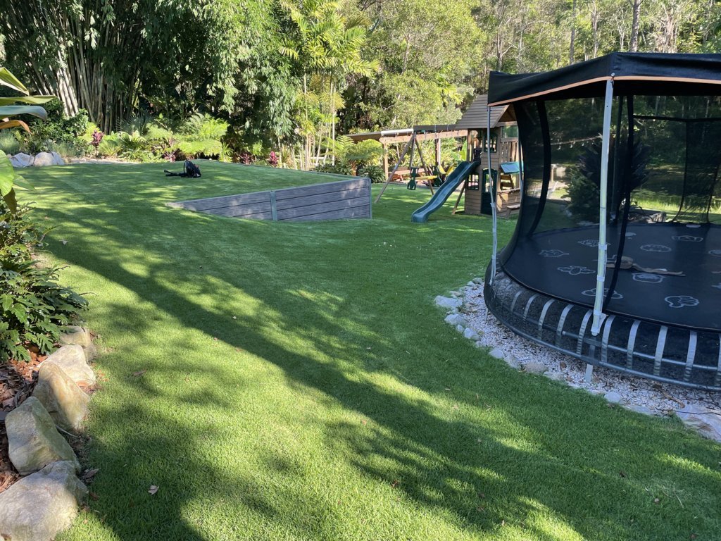 Before lawn tidy around trampoline with leaves on grass
